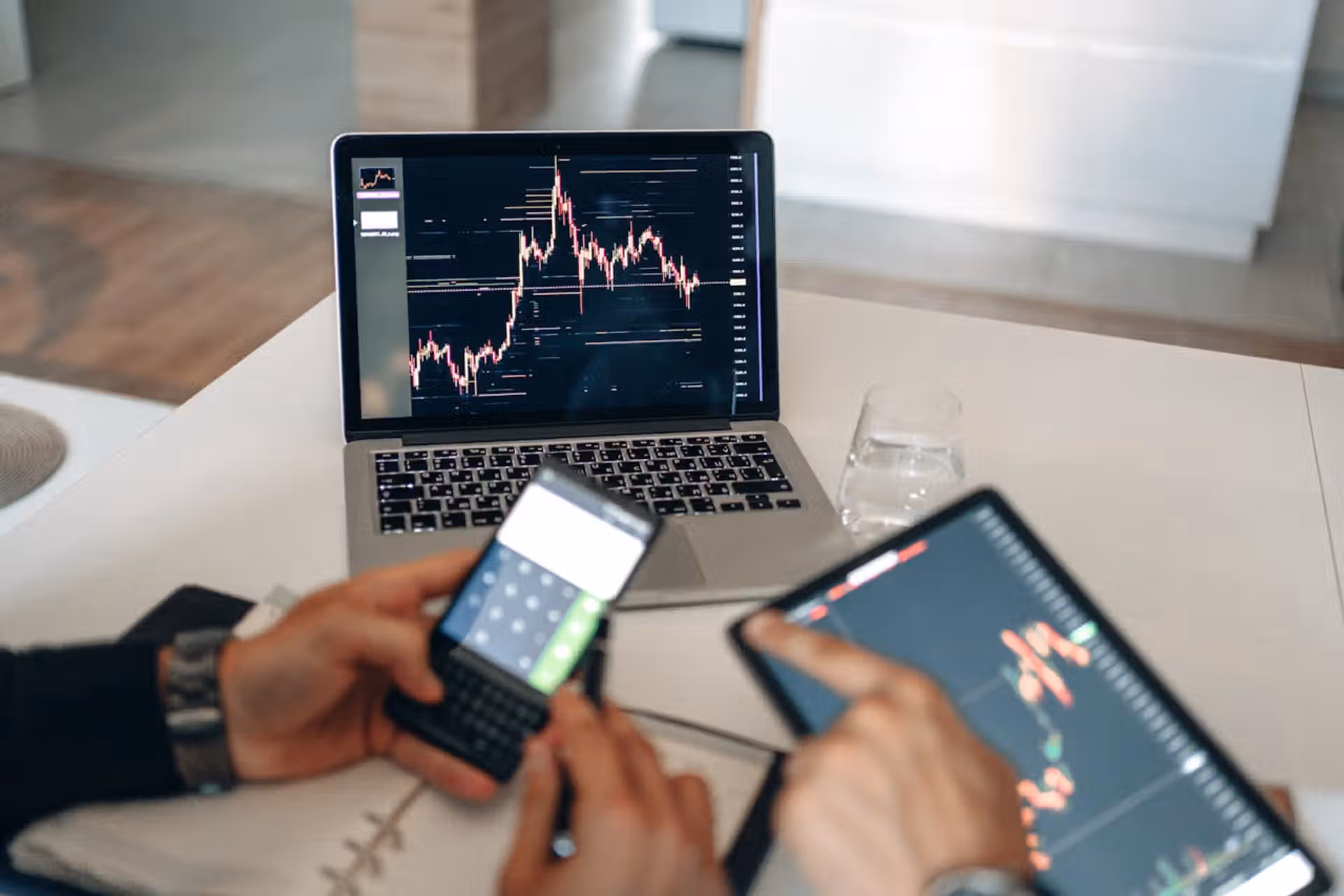 The Art of Drawing Readers In: Your attractive post title goes here Hands using digital devices for financial analysis at a modern desk setup.